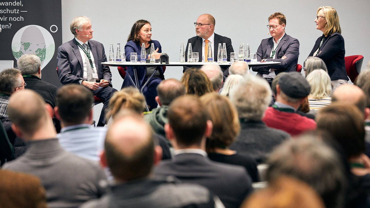 Claus Doll, Mobilitätsexperte, Fraunhofer-Institut für System- und Innovationsforschung ISI, (links) und Marion Jungbluth, Teamleiterin Mobilität und Reisen, Verbraucherzentrale Bundesverband e.V., (2. v. l.) im Gespräch mit den anderen Referenten. 