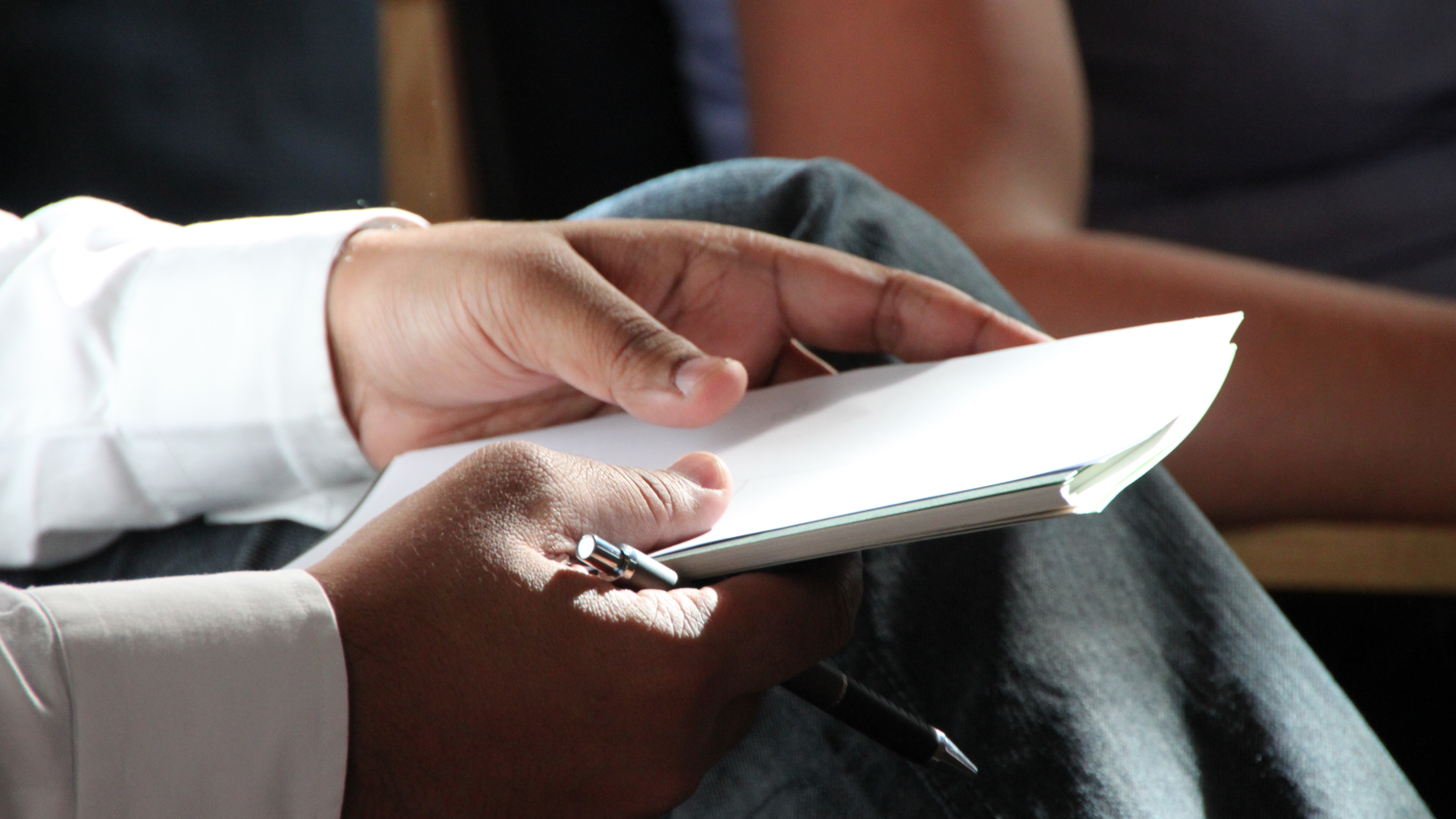 Hands holding a paper and a pen