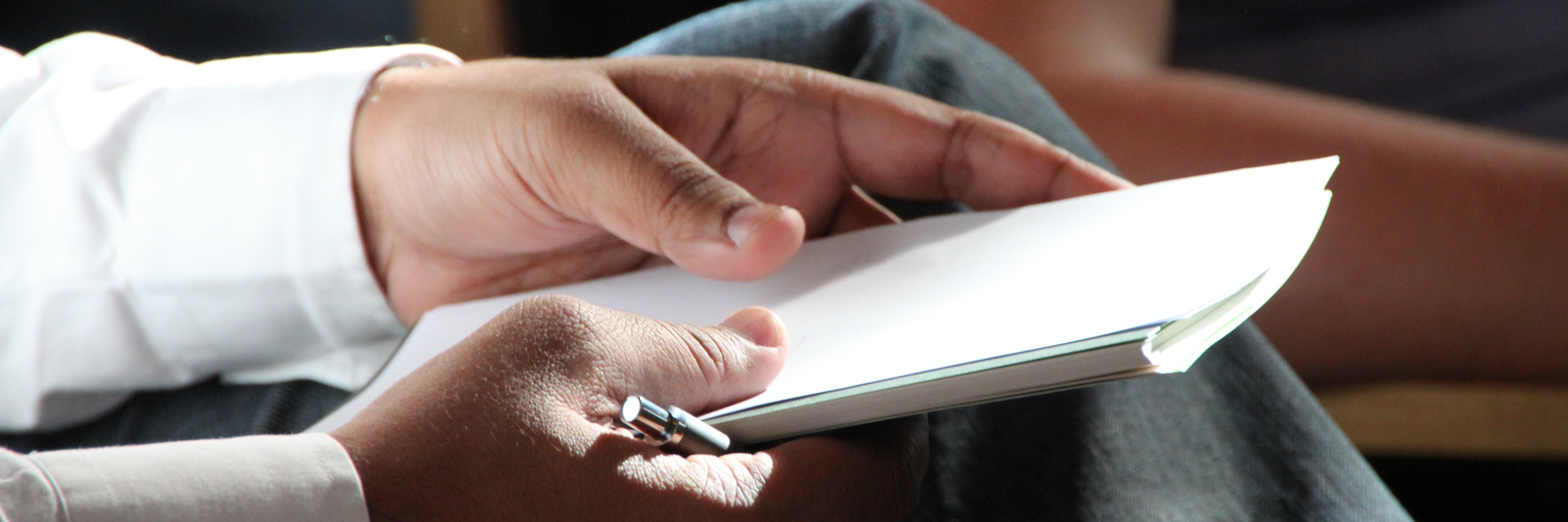 Hands holding a paper and a pen