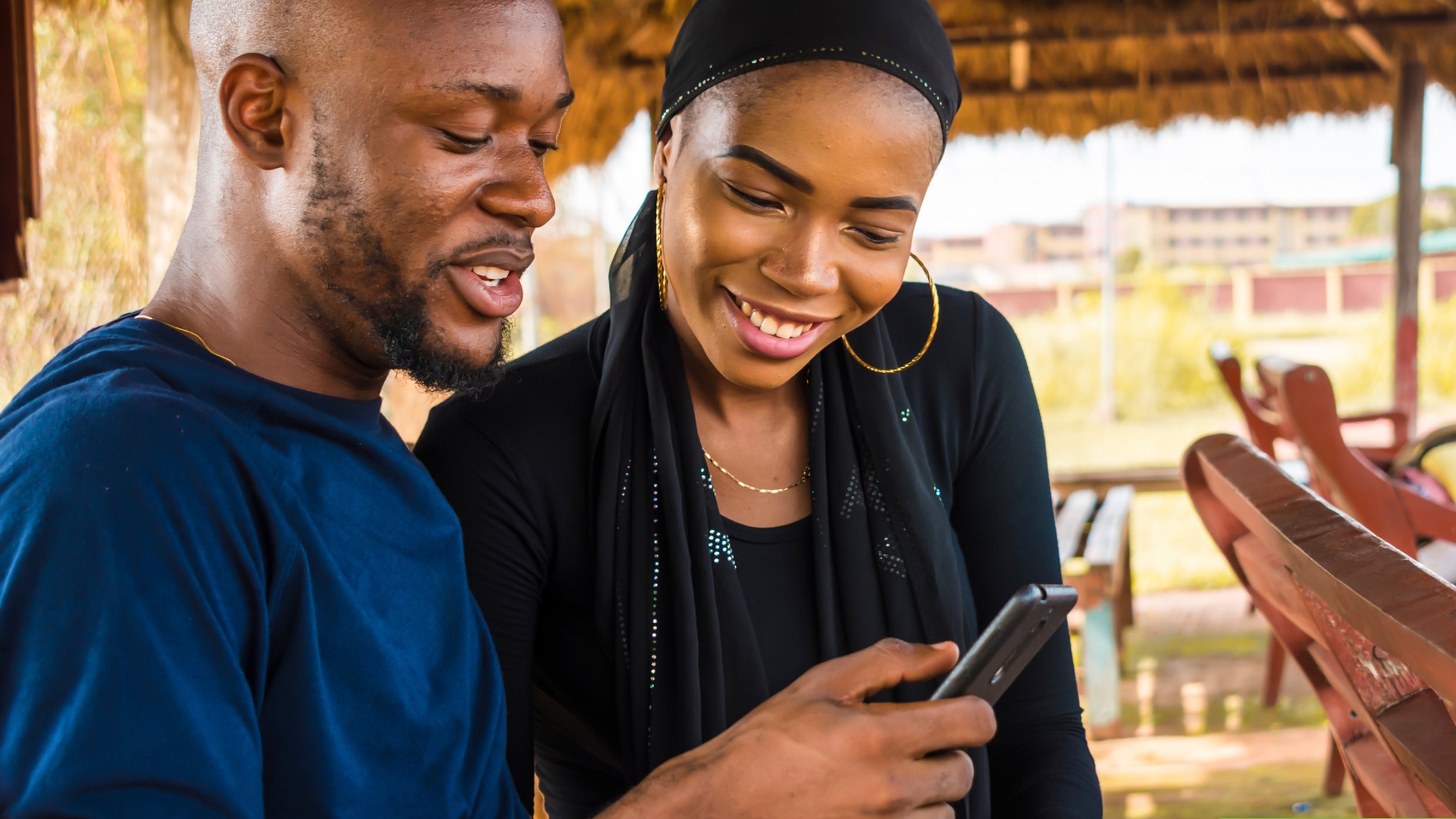 Two people looking at a mobile phone screen