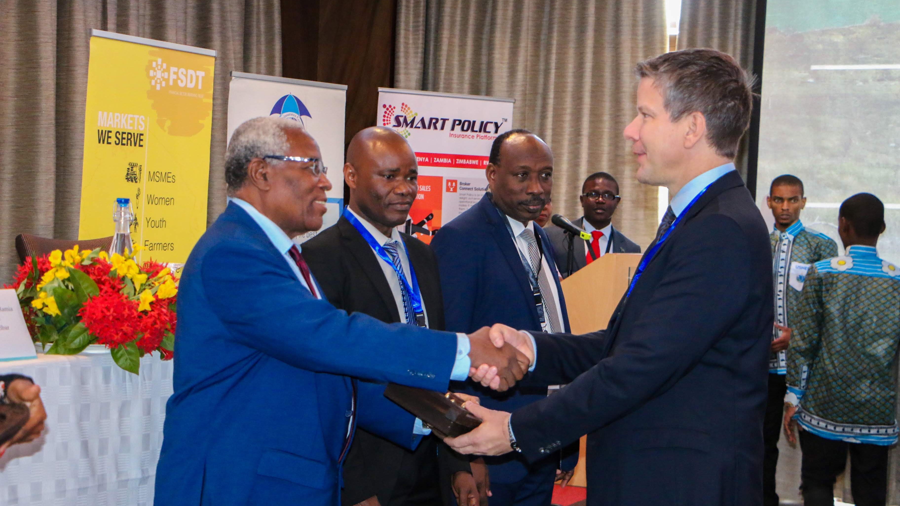Mohamed Ramia Abdiwawa, Minister of Finance and Planning for Tanzania, welcomes Dirk Reinhard, Vice Chairman of the Munich Re Foundation, Germany. Centre left to right: Dr. Mussa C. Juma, Commissioner of Insurance, Tanzania, and Khamis Suleiman, CEO of Sanlam Life Insurance and Chair of the Organising Committee for the conference, Tanzania.