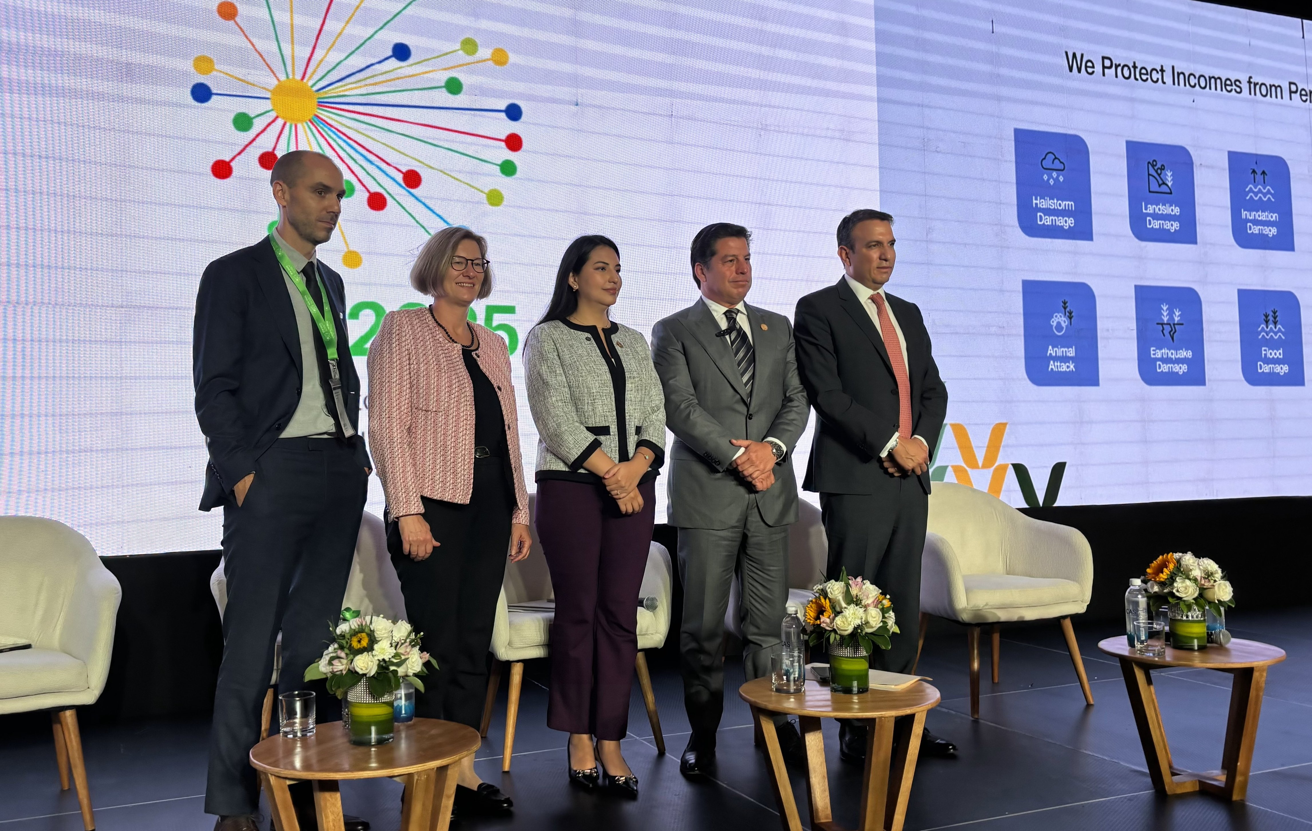 Five individuals stand in front of a large screen displaying colorful graphics and text about income protection.