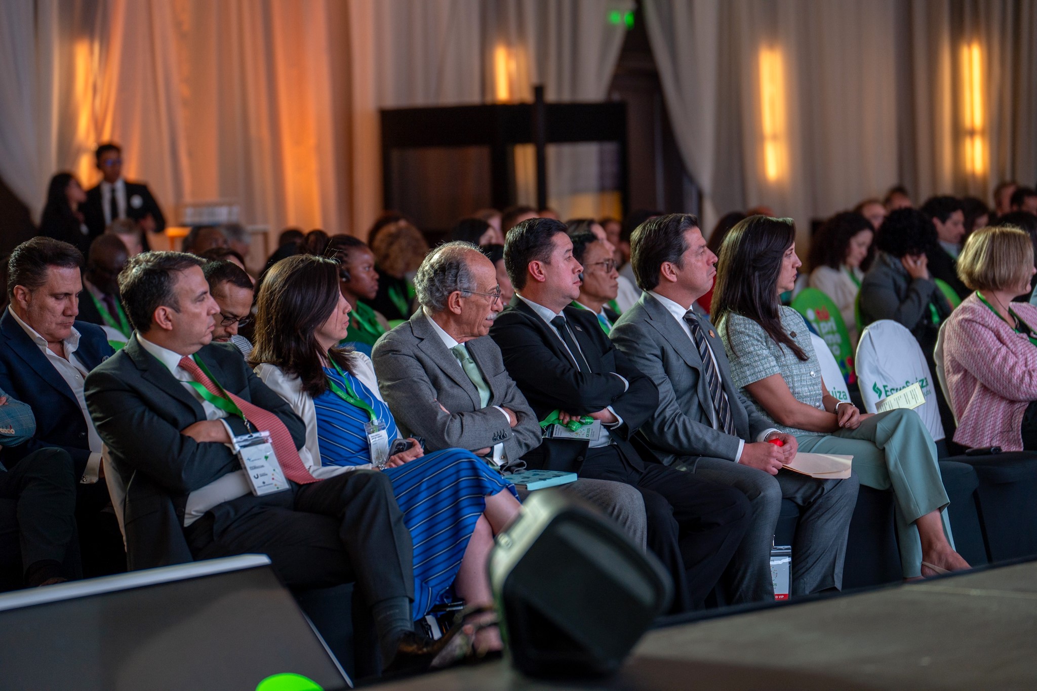 A diverse group of people seated in an auditorium, focused on a presentation or event.