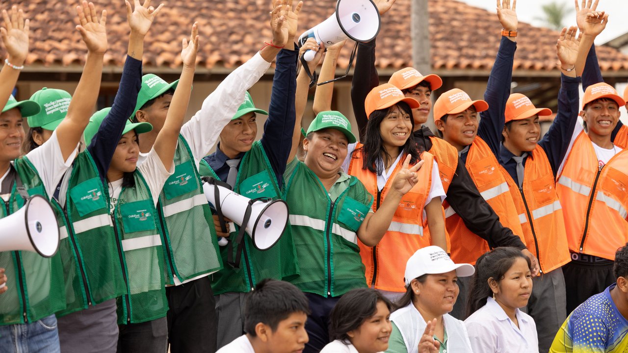 Smiling students in school emergency brigade uniforms wave