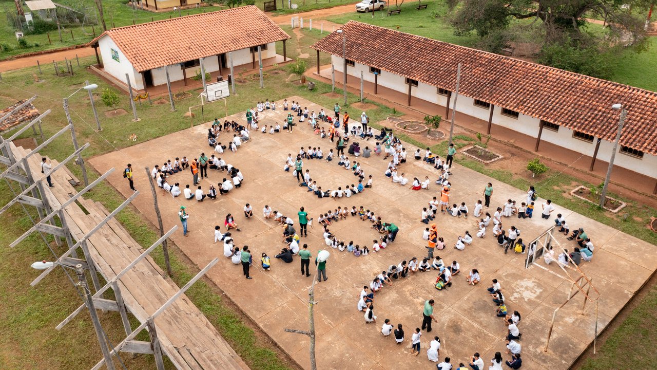 Large groups of students gather in the schoolyard for an emergency drill in Palmarito de la Frontera