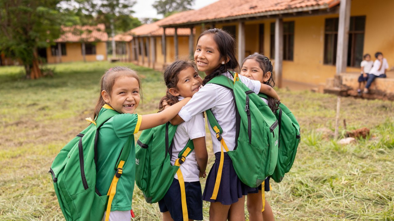 4 students hug each other in front of the school of Monte Verde