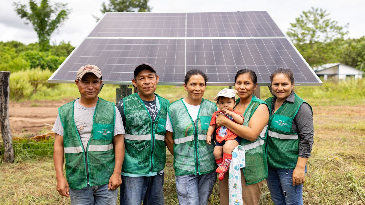 5 people stand behind the solar-powered water system in Monte Verde