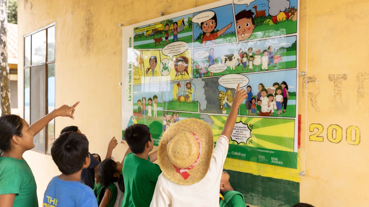 Children learn from the poster about the path to relisience A group of children learn from the poster about the path to relisience